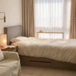 원룸 가구 배치 - 창가 침대 옆에 이중 커튼과 좁은 콘솔을 배치해 냉난방 효율을 높인 아늑한 창가 스타일링.