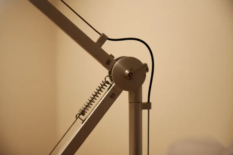 아르떼미데 스타일 스탠드 조명의 관절 스프링과 금속 와이어 구조를 클로즈업하여 마감 상태를 보여주는 디테일 사진.