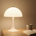 루이스폴센 판텔라 st 조명과 커피, 책이 함께 놓인 모습으로, 가성비 조명이 완성한 도시적인 감성 인테리어.